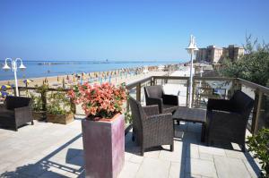 丽都阿德里亚诺Grand Hotel Azzurra Club的一个带椅子的庭院,享有海滩美景