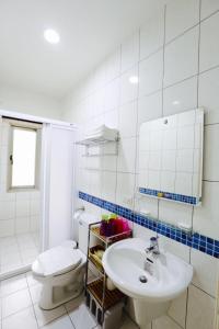 三义乐福民宿的浴室配有白色卫生间和盥洗盆。