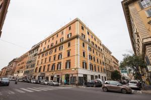 罗马罗马甜蜜住宿旅馆的一条城市街道上一座大型建筑,有停放的汽车