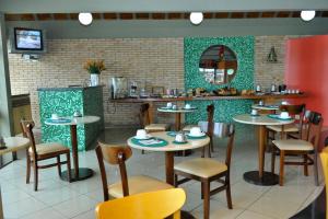 卡萨帕瓦Arcadas Hotel的餐厅设有桌椅和镜子