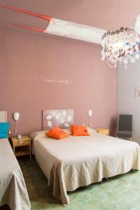 佛罗伦萨全景酒店的一间卧室配有一张带橙色枕头和吊灯的床。