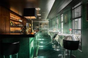 布鲁日范克莱夫酒店的拥有绿色墙壁的餐厅和带桌子的酒吧