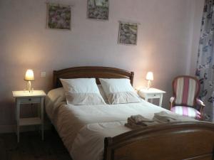 米格龙La Terrasse de la Grand'Rue - chambre d'hôtes -的一间卧室配有一张带两张桌子和两张椅子的床