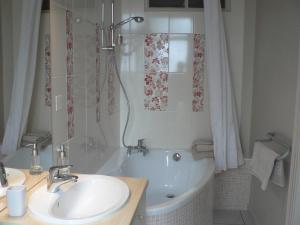 米格龙La Terrasse de la Grand'Rue - chambre d'hôtes -的带浴缸、水槽和淋浴的浴室