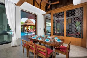 奥南海滩Narintara Private Pool Villas - FREE Tuk-Tuk Service to the Beach!的一间带木桌和椅子的用餐室