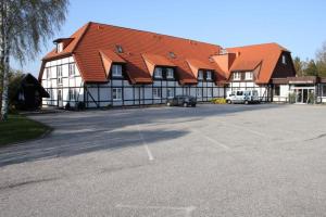 维斯马Hotel Mecklenburger Mühle Garni的一座大型建筑,前面设有停车场