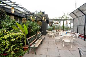 吉大港井柏住宅精品套房酒店的户外庭院设有桌椅和植物