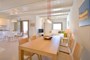 埃利亚海滩Villa Castalia by Thalassa Residence Mykonos的用餐室以及带桌椅的起居室。