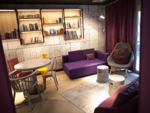 克莱蒙费朗克莱蒙费朗市中心钟楼酒店的客厅配有紫色沙发和椅子