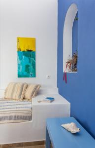 佐努萨岛Althea Studios的一间卧室配有一张床和一张蓝色的桌子