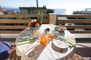 阿尔盖罗Elena House的一张桌子,上面放着一碗水果和一碗橙汁