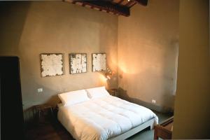 布里西盖拉Azienda Agricola Baccagnano的卧室内的一张床铺,墙上有两张照片