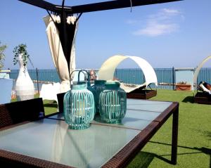 里米尼Residence Frontemare的两只蓝色花瓶坐在桌子上,放在伞下