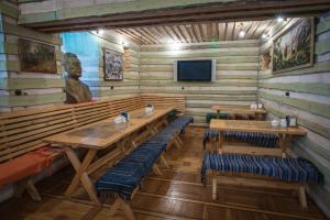 阿拉木图新布拉克度假酒店的用餐室设有木桌、长凳和雕像