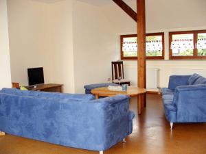 FrielendorfFerienwohnung Am Jakobsweg的客厅配有2张蓝色的沙发和1张桌子