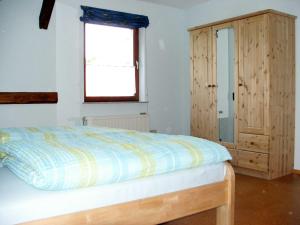 FrielendorfFerienwohnung Am Jakobsweg的一间卧室配有一张床和一个木制橱柜
