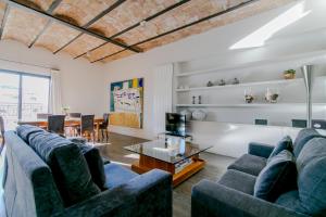 巴塞罗那Decô Apartments Barcelona-Diagonal的客厅配有蓝色的沙发和桌子