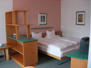Nötsch马尔科酒店的一间卧室配有一张床和一张书桌及电视