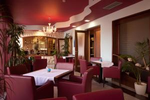 乌马格酒兹拉特娜瓦拉酒店的一间带桌椅和菜单的餐厅