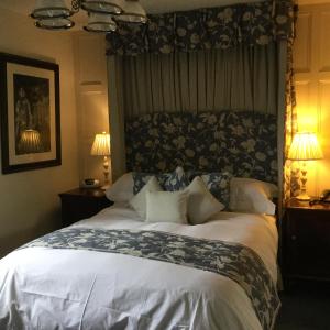 格兰瑟姆The Brownlow Arms Inn的卧室内的一张大床,配有两盏灯