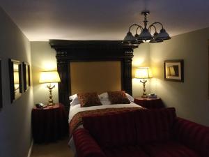 格兰瑟姆The Brownlow Arms Inn的一间卧室配有一张床、两盏灯和一张沙发。