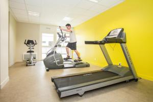 奥尔良奥尔良市圣约翰奥德利公寓式酒店的一个人在健身房跑步机上锻炼