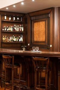 卡兰巴卡卡斯特拉奇酒店的一间酒吧,位于一个拥有木墙和木凳的房间