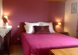 桑吉内Les Arums de Sanguinet的卧室配有带白色枕头的紫色床