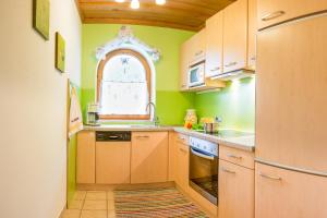 施图拜河谷新施蒂夫特豪斯拉且尔旅馆的厨房设有绿色的墙壁、木制橱柜和窗户。