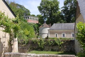 Poncé sur Le LoirLA PONCÉ SECRÈTE的远处的一座古房子和一座城堡