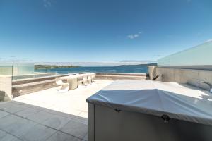 陶波圣水陶波酒店的阳台享有海景,配有桌椅。