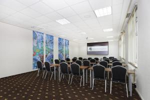 拉辛4元素法兰特奥罗德克会议与培训中心酒店的一间会议室,配有桌椅和屏幕