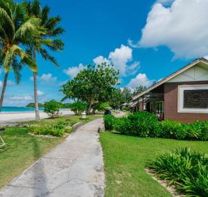 拉古洼玛扬萨瑞海滩假日酒店的棕榈树和人行道的海滩上的房子