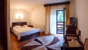 沃拉内特佩拉布考韦内酒店的一间卧室配有一张床、一台电视和一张地毯。