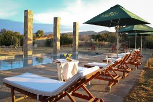 奥瓦列利马里酒店的一排带遮阳伞和游泳池的躺椅