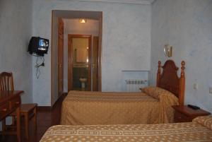 阿维拉贝拉斯旅馆的酒店客房设有两张床和电视。