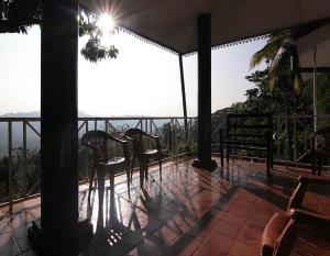 康提康提二合一旅舍的阳台配有椅子,享有海景。