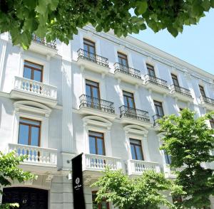 马德里Hotel Único Madrid, Small Luxury Hotels的大型白色建筑,设有窗户和阳台
