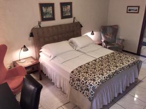 伊瓜苏El Refugio的一间卧室配有一张大床和一把椅子