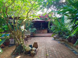 伊瓜苏El Refugio的一座花园,花园内有砖砌的步道,种植了树木和植物