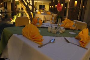 库塔桑提卡库塔酒店的一张桌子,上面有黄色的餐巾和餐具