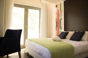 巴尔基尼亚新镇Barquinha River House的一间卧室设有一张床、一个窗口和一把椅子