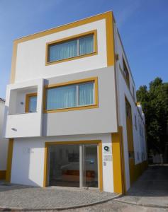 巴尔基尼亚新镇Barquinha River House的白色的建筑,带有黄色的点缀