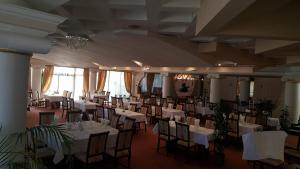 阿拉德总统酒店的宴会厅配有白色的桌椅