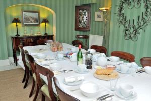 MereB&B Castleton House的一间用餐室,配有白色菜肴的桌子