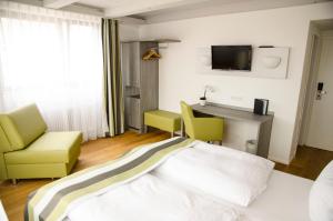 海德堡施洛斯酒店的一间卧室配有一张床、两把椅子和一张书桌