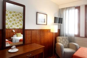 IlomantsiHotelli Pogostan Hovi的酒店客房设有镜子、椅子和床