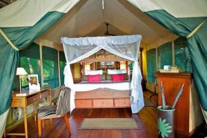 Archers PostSamburu Intrepids Tented Camp的帐篷内的卧室,配有一张床和一张书桌