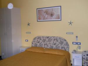 阿尔本加索尔马尔酒店的卧室配有一张床,墙上挂着一幅画