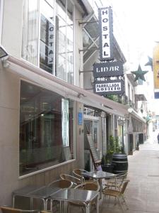 拉科鲁尼亚线性旅馆的餐厅外一条带桌椅的空人行道